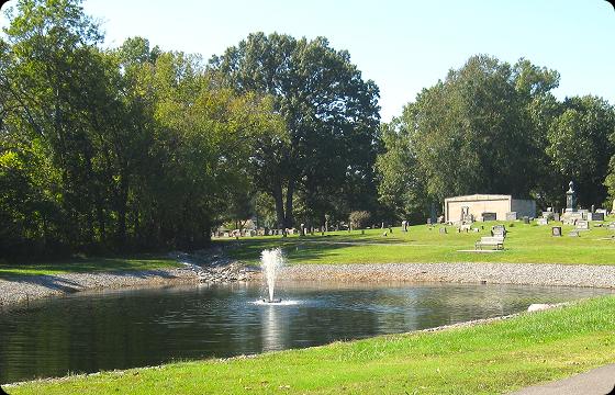 A pond with a fountain in a cemetery